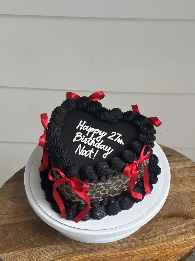 Black heart cake with red bows, leopard print sides and a 27th birthday message