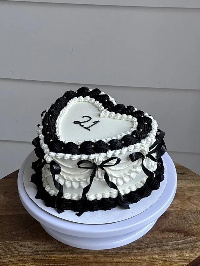 Small white heart cake with black piping, black bows and a 21