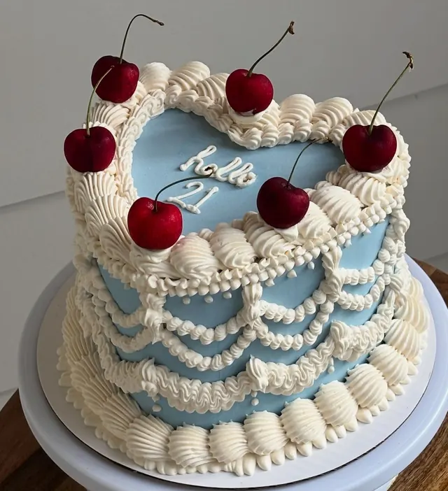 Blue heart cake with ivory drape piping, fresh cherries and "hello 21."