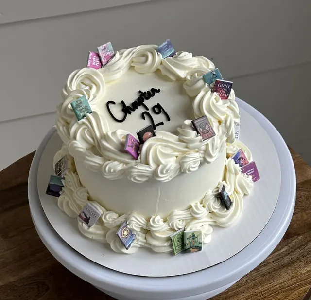 White round cake with mini book decorations and "Chapter 29."