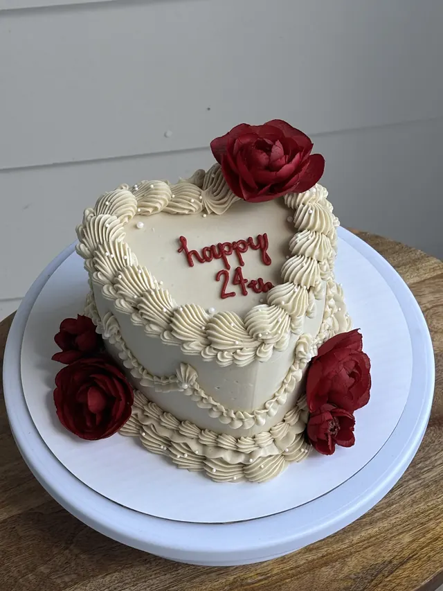 Ivory heart cake with red roses and "happy 24th" in red