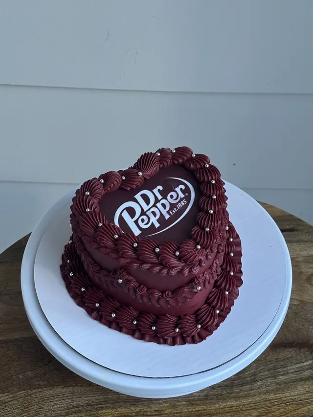 Burgundy heart cake with a Dr Pepper logo and pearl borders