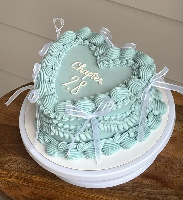 Dusty blue heart cake with sheer white bows and "Chapter 28."