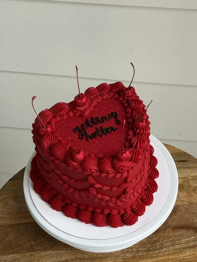 Red heart cake with cherries and "getting hotter."
