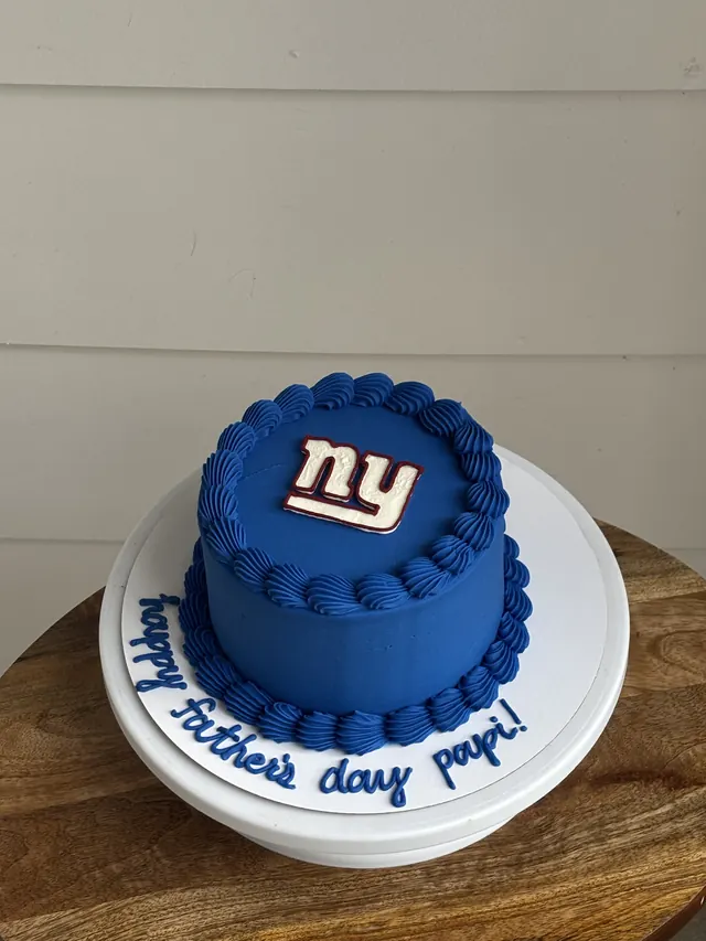 Blue round cake with a NY Giants logo and a Father's Day message on the board