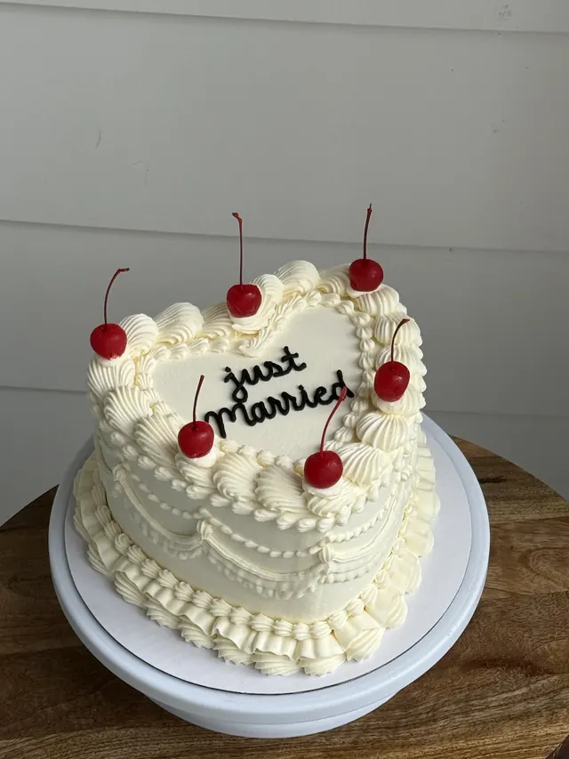 Ivory heart cake with cherries and "just married."