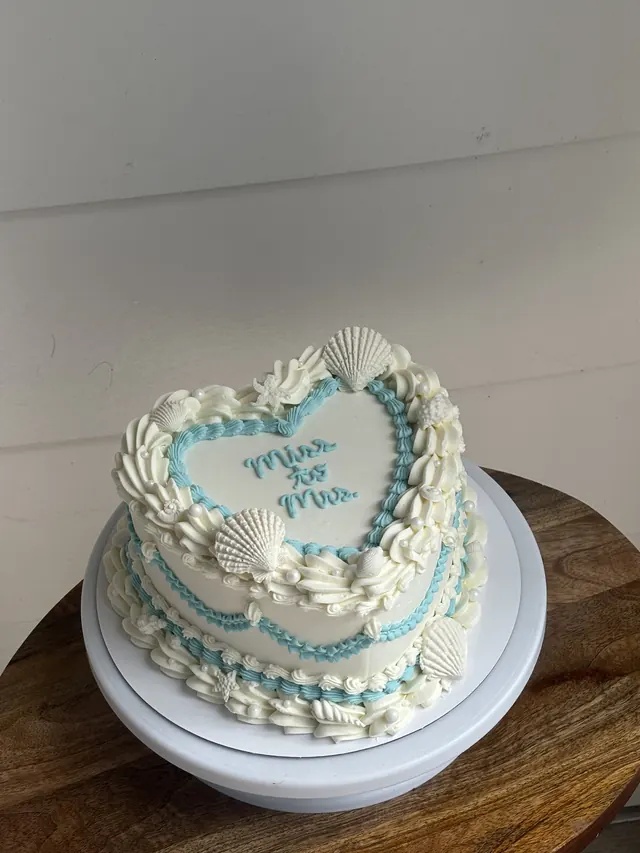 Ivory heart cake with blue piping, seashells and "miss to mrs."