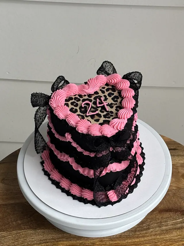 Tall black and pink heart cake with a leopard print top, black lace bows and a 24