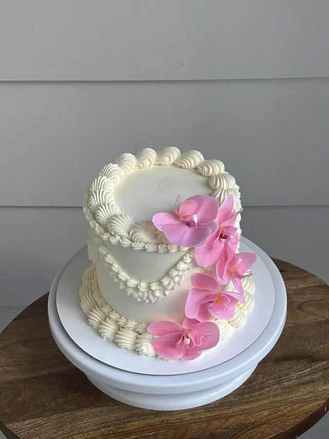 Tall ivory round cake with pink orchids