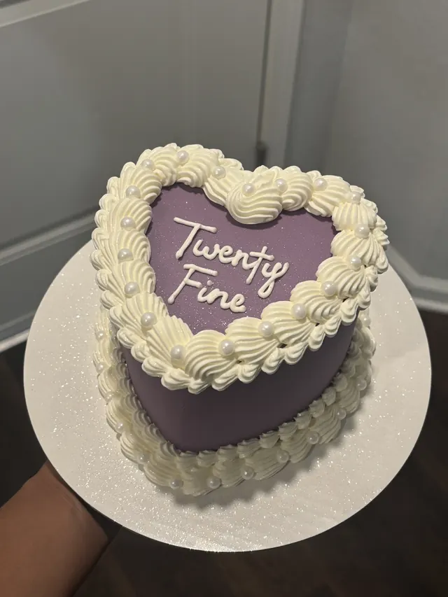 Small purple heart cake with ivory piping, pearls and "Twenty Fine."