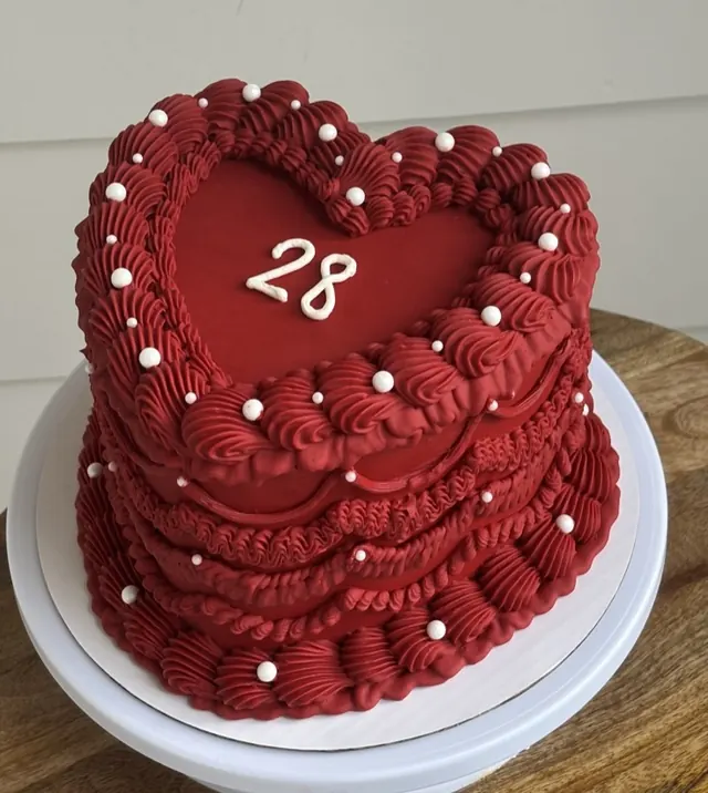 Deep red heart cake with white pearls and a white 28