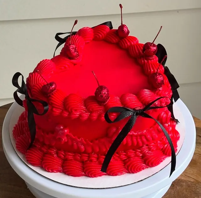 Bright red heart cake with glitter cherries and black satin bows