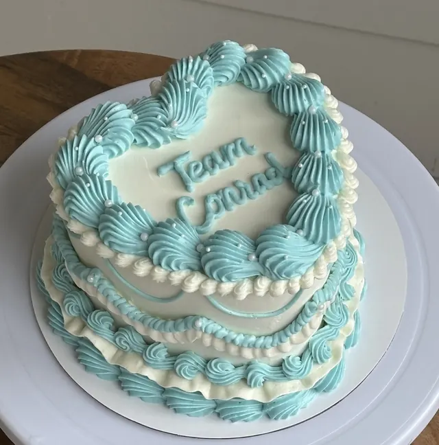 Aqua and white heart cake with "Team Conrad."
