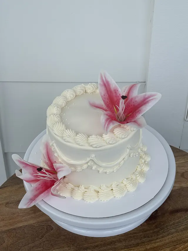 Ivory round cake with pink stargazer lilies