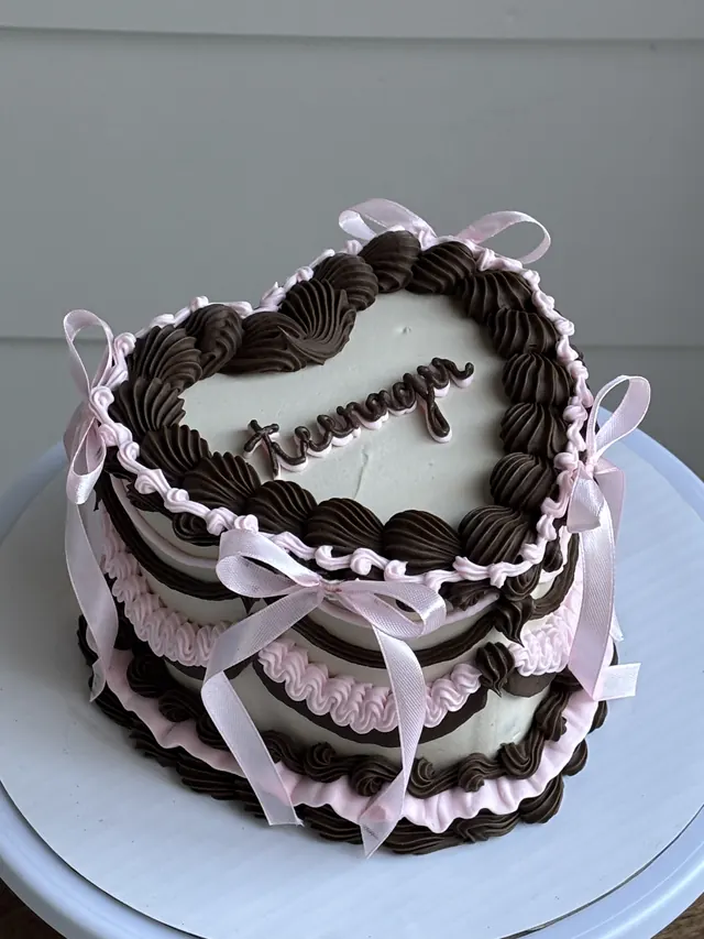 White heart cake with chocolate piping and pink bows