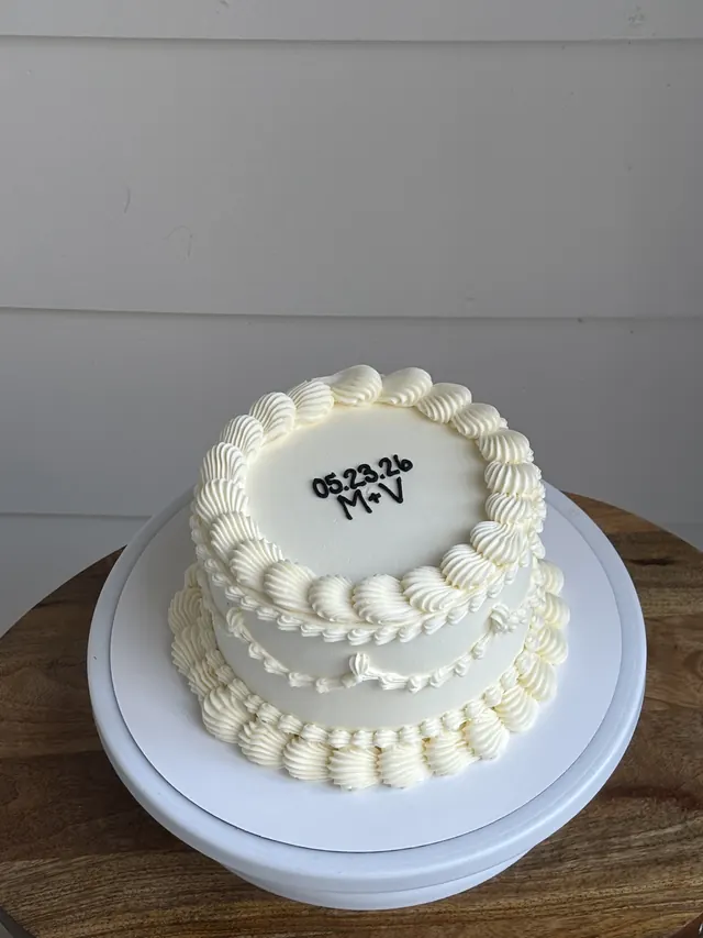 Ivory round cake with the couple's initials and wedding date