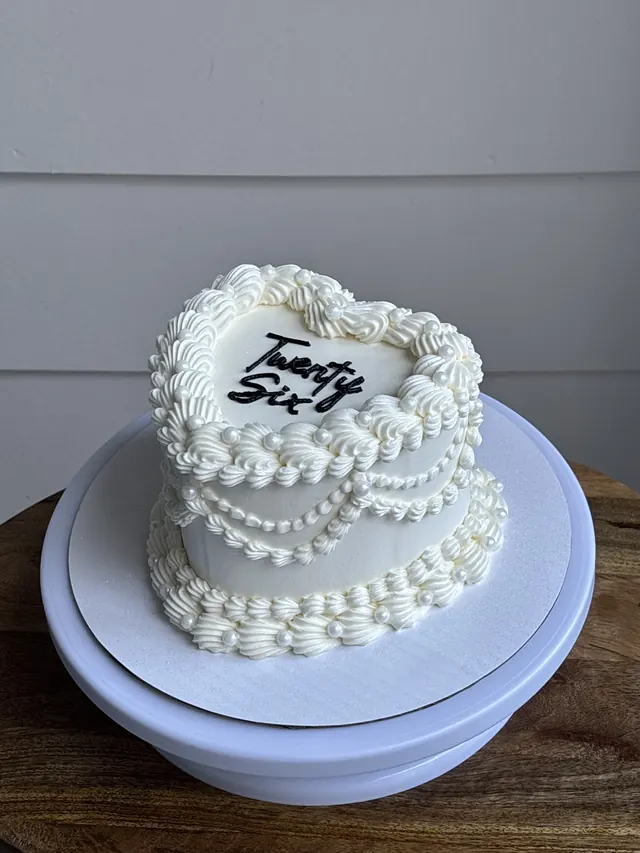 Small white heart cake with pearl borders and "Twenty Six."